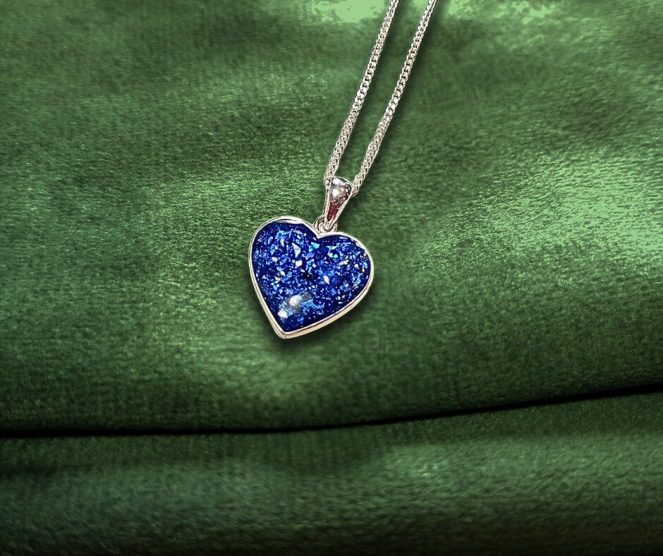 sapphire heart ashes memorial pendant on green velvet background