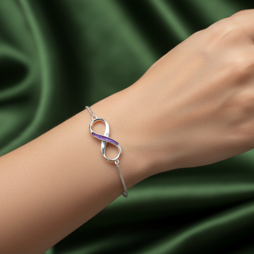Silver infinity ashes memorial bracelet on a models wrist with green fabric background