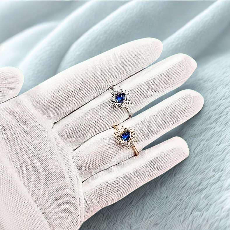 ashes vintage halo ring in silver and gold on model with white velvet background