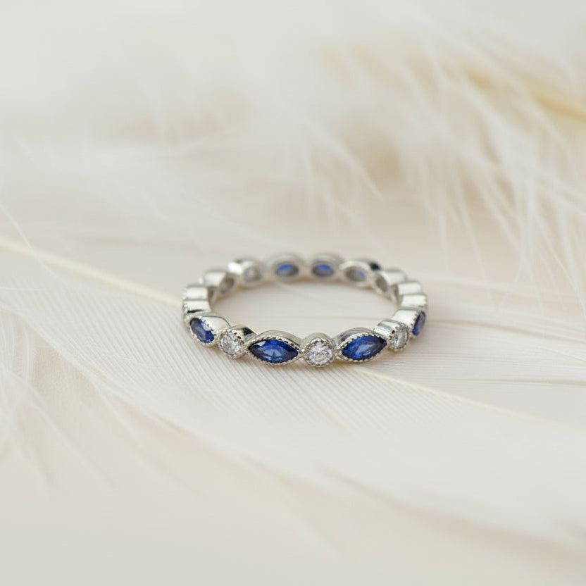 ashes eternity ring featuring birthstones on a feather background
