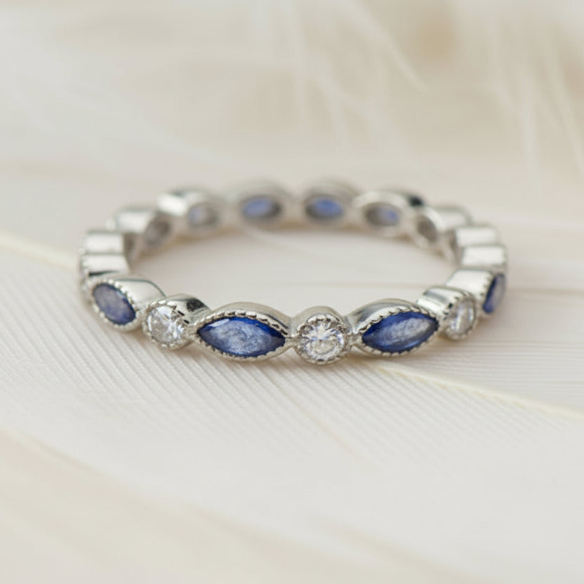 ashes eternity ring featuring birthstones on a feather background
