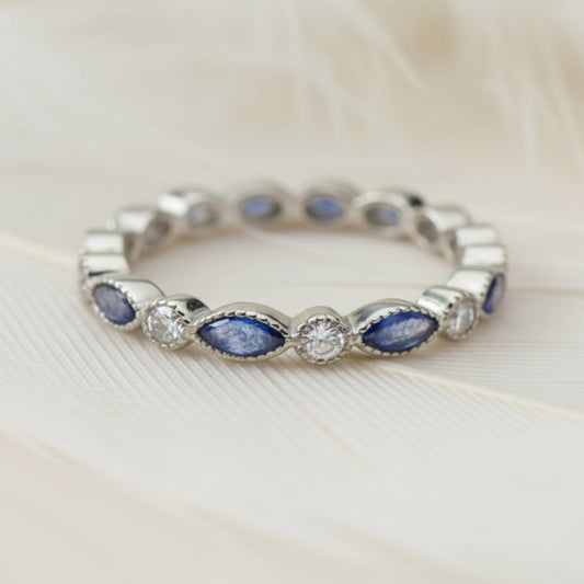ashes eternity ring featuring birthstones on a feather background