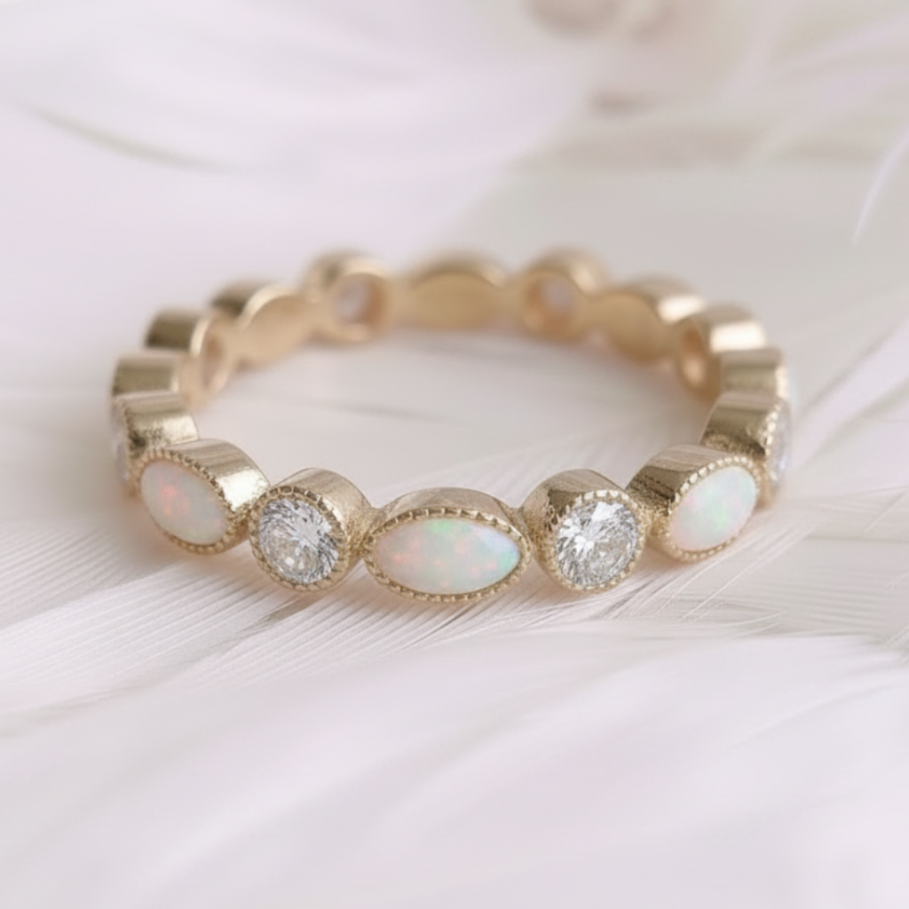 A 14ct /18ct gold ashes eternity ring set with opal ashes stones, and genuine natural diamonds, resting on a soft white feather background.