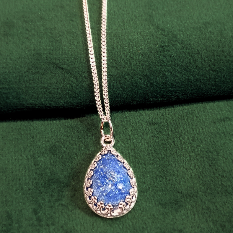 vintage filigree silver ashes necklace on green velvet