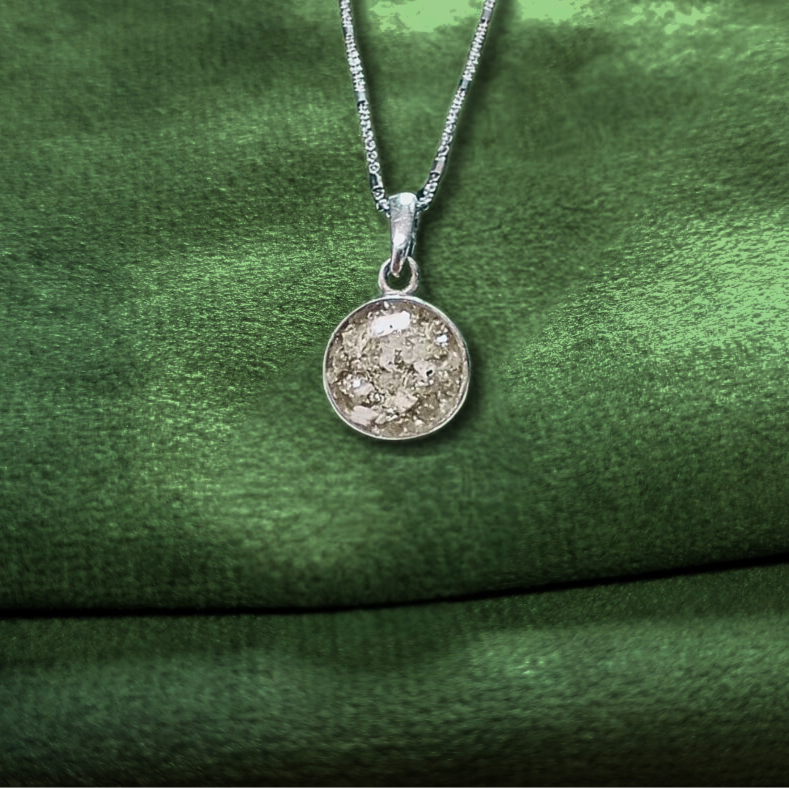 simple round ashes pendant on green velvet background