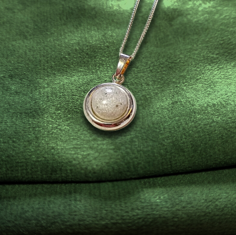 round pearl ashes necklace on green velvet