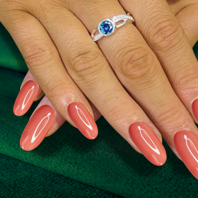 twist crossover ashes ring with round blue stone on hand with long peach nails