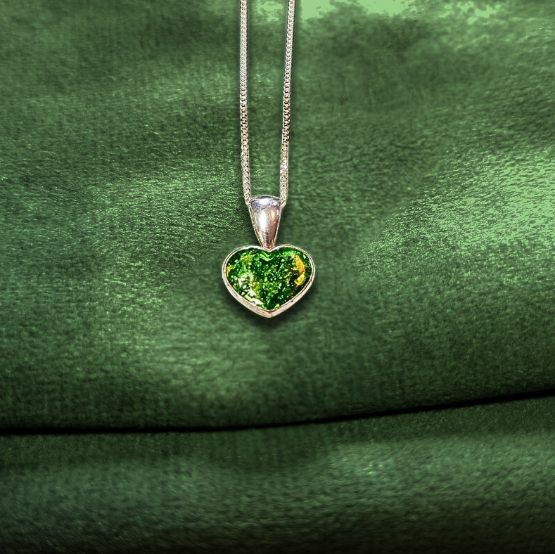 small peridot heart memorial necklace on green velvet background