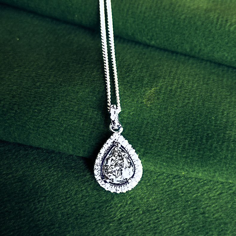 teardrop halo ashes necklace on green velvet background